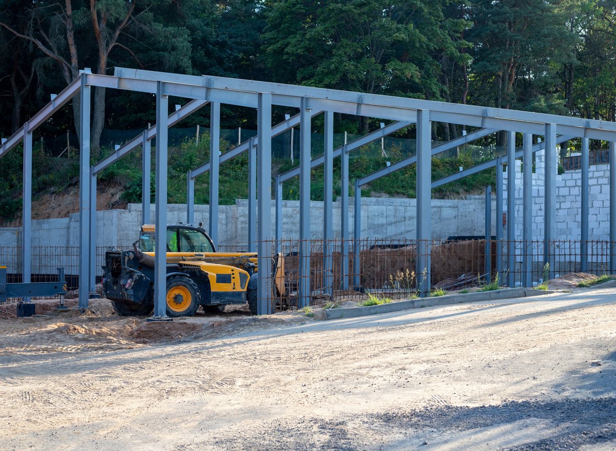 Telescopic loader working at a building under construction in the evening
